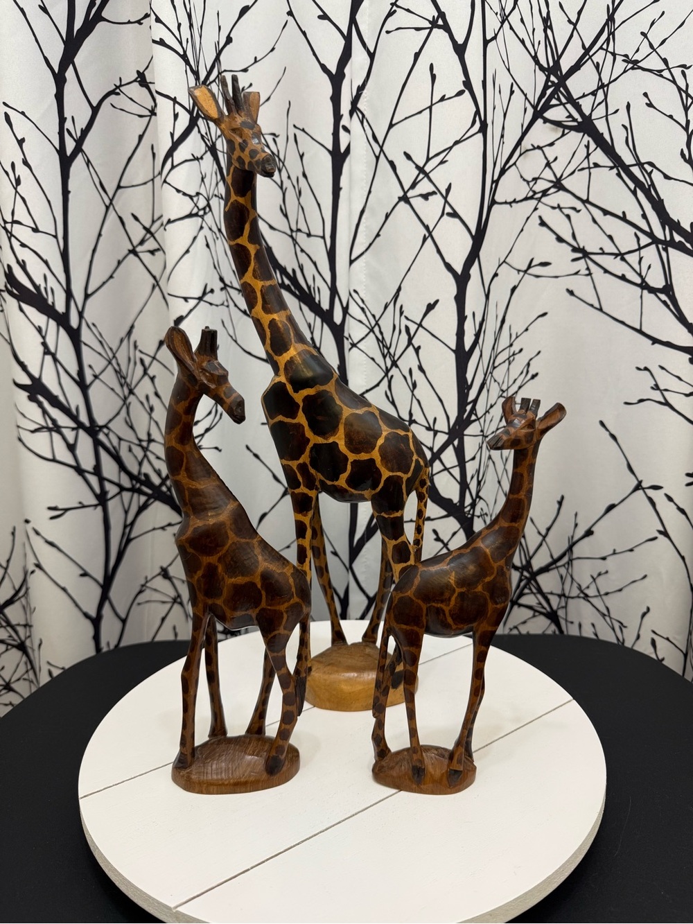 Three hand-carved wooden giraffe sculptures
